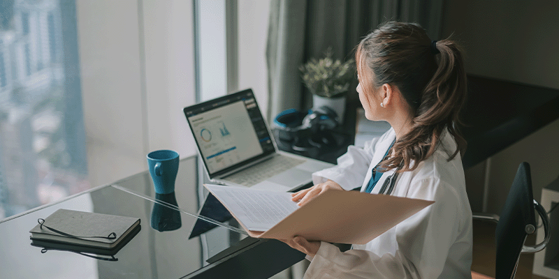 physician reviewing society guidelines on laptop
